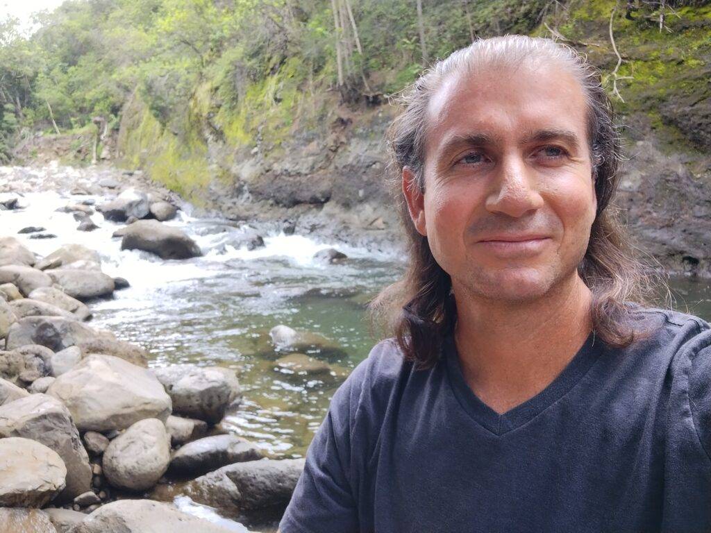 Ugo Tsalapatanis, hypnotherapist, by the stream in Iao Valley, Maui